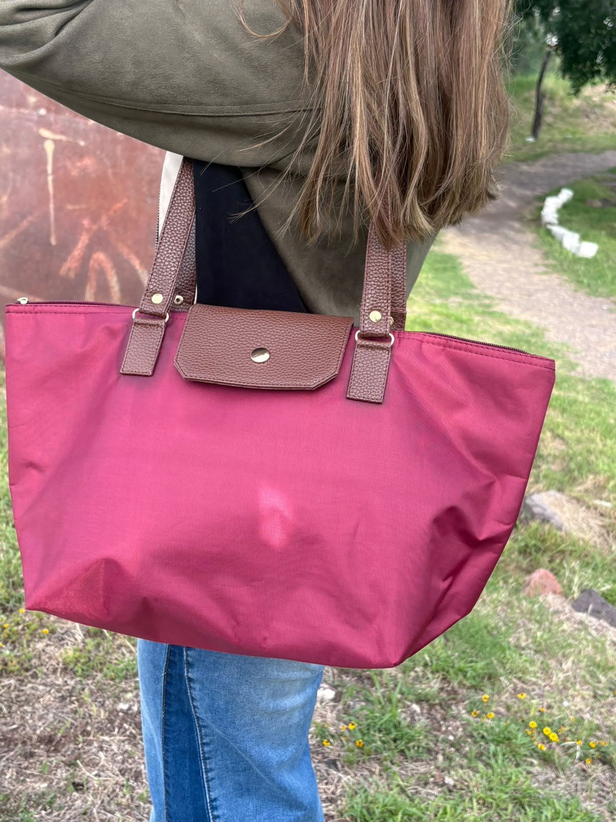 Bolso tote MARSELLA en nylon cereza con asas de piel, llevado al hombro por una modelo en exterior